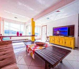 sala de estar con TV y mesa de madera en Espetacular! Casa de Praia em Arraial do Cabo, en Arraial do Cabo