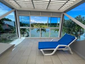 un sillón azul en un porche con vistas al agua en LAKE HOUSE RESORT COUNTRY CLUB & SPA, en Santander de Quilichao