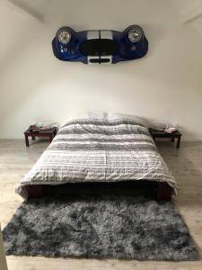 ein Schlafzimmer mit einem Bett mit einem Lautsprecher an der Wand in der Unterkunft Le Domaine d'Angélique in La Vespière