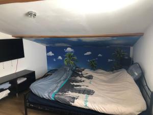 - une chambre avec un lit orné d'une peinture de palmiers dans l'établissement Maison de village avec patio, à Bessan