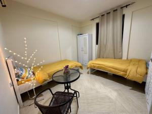 a room with two beds and a table and chairs at Private Room Shared Apartment Flat31-R1 in Abu Dhabi