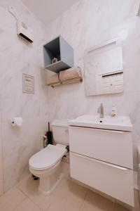 a white bathroom with a toilet and a sink at Bright View in Dublin