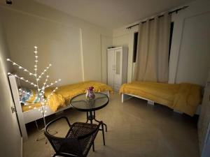 a small room with a table and two beds at Private Room Shared Apartment Flat31-R1 in Abu Dhabi