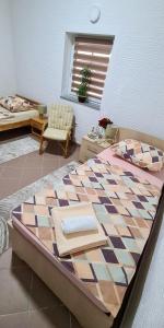 um quarto com uma cama grande e uma cadeira em Prenoćište Dubravka em Livno