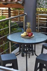 una mesa con una piña y un plato de fruta. en Villa Emmanuel en Karteros