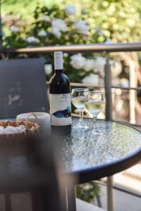 卡特羅斯的住宿－Villa Emmanuel，桌子上放有一瓶葡萄酒和两杯酒
