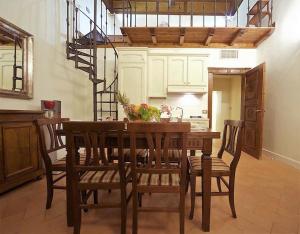 uma cozinha com uma mesa de madeira com cadeiras e uma escada em Residenza Sinibaldi em Roma