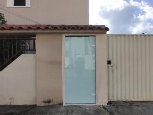 a white door on a building with a fence at 102 Apartamento em Aracruz ES in Aracruz