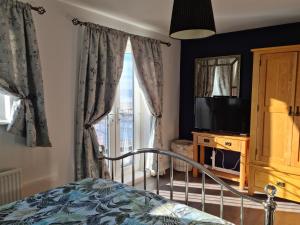 - une chambre avec un lit, une télévision et une fenêtre dans l'établissement Beach View Couples Retreat Aberavon Beach Direct Seafront, à Port Talbot