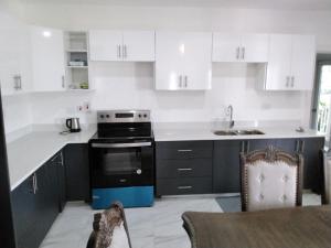 a kitchen with black and white cabinets and a stove at Lavue in Kingston