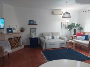 ヴィラ・ノヴァ・デ・ミルフォンテスにあるLagoa azul guest houseのリビングルーム(ソファ、暖炉付)