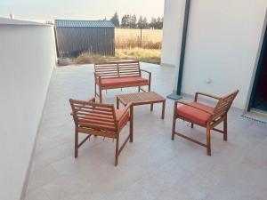 three chairs and a bench on a patio at Serenity, parking gratuit , 5 min Auxerre in Monéteau
