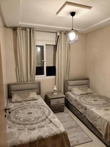 1 Schlafzimmer mit 2 Betten und einem Fenster in der Unterkunft Puerta Del Mar Apartment complex in Tangier