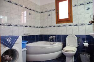 a bathroom with a toilet and a tub and a sink at Magdas house in Alonnisos +26 photos