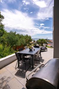 un patio con tavolo e sedie sul balcone. di Panorama Suite Dora with Jacuzzi a Palit