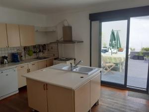 a kitchen with a sink and a view of a patio at spacieux T5 Quimper centre in Quimper