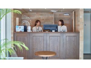 two women standing at a counter with a computer at 8HOTEL CHIGASAKI - Vacation STAY 87540v in Chigasaki +81 photos