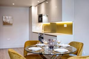 een eetkamer met een tafel en stoelen met wijnglazen bij Marble Arch Suite 5-Hosted by Sweetstay in Londen