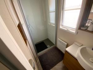 a small bathroom with a sink and a window at camping de la falaise à equihen plage in Équihen-Plage