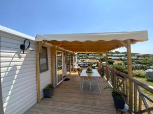 um deque de madeira com uma pérgola numa casa em camping de la falaise à equihen plage em Équihen-Plage