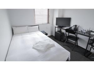 a bedroom with a bed and a desk with a computer at 8HOTEL CHIGASAKI - Vacation STAY 87519v in Chigasaki