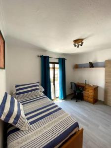 1 dormitorio con 2 camas, escritorio y ventana en Casa MIJAS PUEBLO La Villa Nueva en Mijas