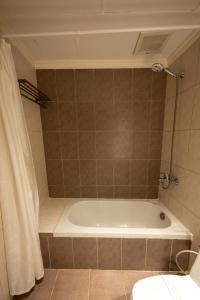 a bathroom with a bath tub and a toilet at Tanal Serviced Apartments in Al Khobar