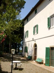 CollemezzanoにあるCase Vacanze Odifrediの緑のシャッターとテーブルが前に並ぶ建物