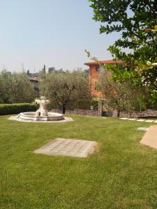 a park with a fountain in the middle of a lawn at Casa Silvia in Padenghe sul Garda