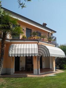 una casa con un toldo blanco y una palmera en Casa Silvia, en Padenghe sul Garda