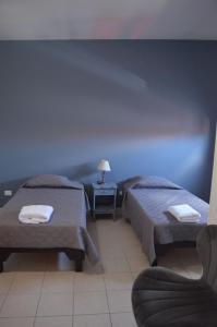 una habitación de hotel con 2 camas y una silla en Suites Cervantes, en Chihuahua