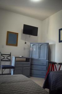 1 dormitorio con escritorio, vestidor y cama en Suites Cervantes, en Chihuahua