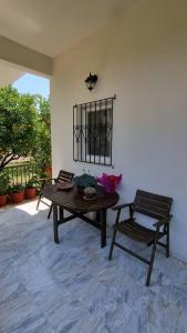 a room with a wooden table and a chair at Gabriel's house in Asíni