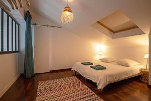 1 dormitorio con cama y lámpara de araña en Duplex Carnon en Carnon-Plage