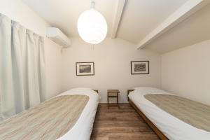 two beds in a room with white walls at Kiyomizu Donguri-an - Vacation STAY 14648 in Kyoto