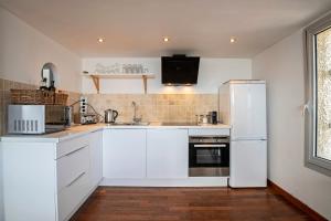 una cucina con armadietti bianchi e frigorifero bianco di Duplex Carnon a Carnon-Plage