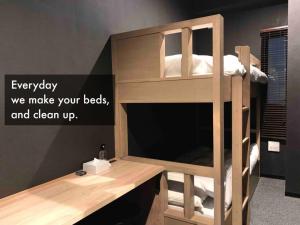 ein Etagenbett aus Holz mit einem Schreibtisch in einem Zimmer in der Unterkunft 9 C Hotel Asahikawa - Vacation STAY 58446v in Asahikawa