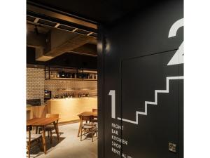 ein Restaurant mit einer schwarzen Wand mit einem Ausstiegszeichen in der Unterkunft 9 C Hotel Asahikawa - Vacation STAY 58446v in Asahikawa