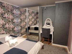 a bedroom with a bed and a desk with a mirror at lägenhet i Borgholms villa in Borgholm