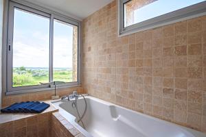 a bathroom with a bath tub and a window at Duplex Carnon in Carnon-Plage