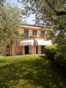 un edificio con toldo en un patio con árboles en Casa Silvia, en Padenghe sul Garda