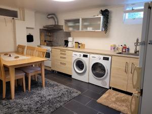 a kitchen with a washing machine and a table at lägenhet i Borgholms villa in Borgholm