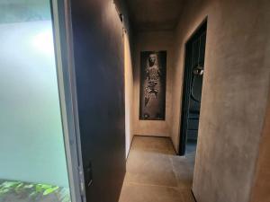 un corridoio con un dipinto sul muro accanto a una porta di Casa Gaia a Nosara