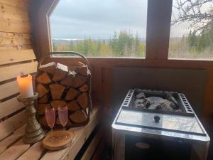 um quarto com uma vela e uma mesa com uma janela em Forest cabin with stunning mountain view & Sauna em Torsby