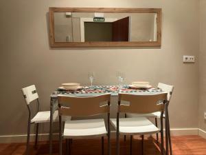 a dining room table with chairs and a mirror at APARTAMENTO CALLE CURIA 6 in Pamplona