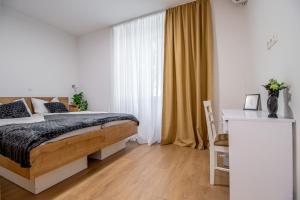 a bedroom with a bed and a desk and a window at Apartments Euphoria East in Rijeka