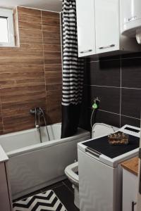 a small bathroom with a toilet and a bath tub at Stan na dan - Valikavali in Novi Pazar