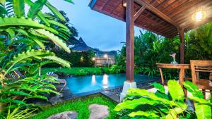 uma piscina num jardim com uma pérgola em Uma Kakul Villas em Tegalalang