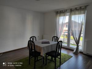 a dining room with a table and chairs and a window at Meri rooms in Bihać