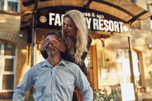 a woman standing behind a man in front of a building at FACTORY RESORT wellness & spa in Kołobrzeg